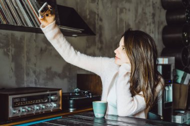 büyüleyici bir gülümseme ve kahve içme ve bir smartphone kullanarak ifade kahverengi gözlü güzel bir esmer kız