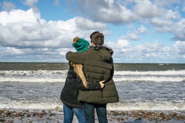 genç bir çift hafta sonları deniz kenarı soğuk Baltık Denizi, kumsalı, sıcak ceketler, Aile hafta sonu erkek ve kadın plajda çalışan harcama aşık.