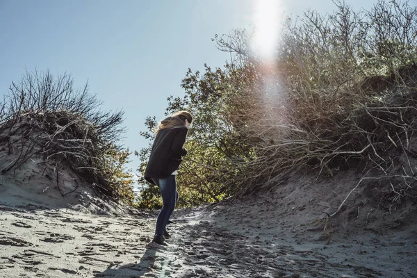 穿着温暖夹克的长发女孩 沿着寒冷的波罗的海海滩散步 — 图库照片