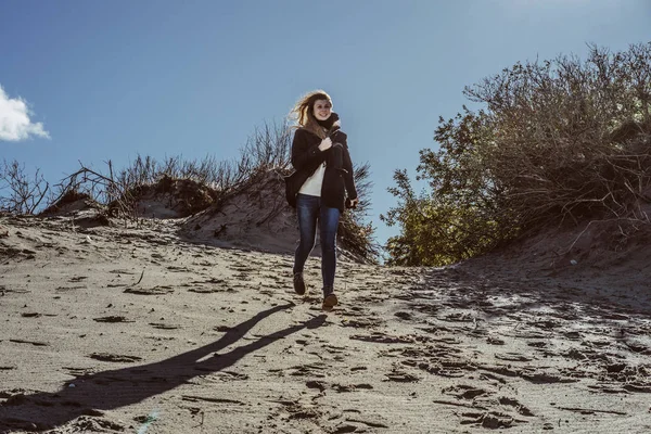 sıcak bir ceket, uzun saçlı kız soğuk Baltık Denizi sahil boyunca yürüyüş