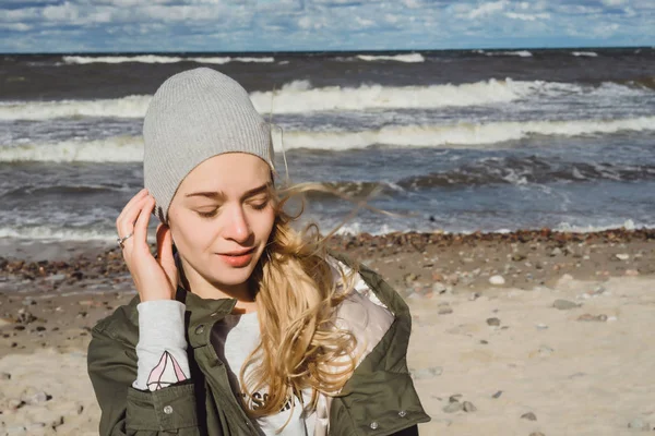 寒いバルト海のビーチに沿って歩いて暖かいジャケットで長い髪の女の子 — ストック写真