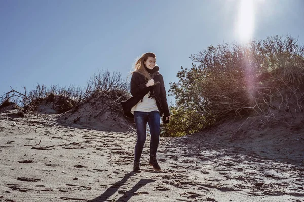 sıcak bir ceket, uzun saçlı kız soğuk Baltık Denizi sahil boyunca yürüyüş