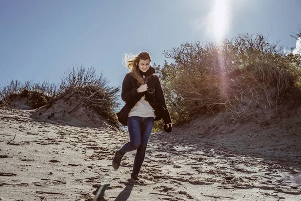 sıcak bir ceket, uzun saçlı kız soğuk Baltık Denizi sahil boyunca yürüyüş