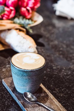 Bir kupa kahve cappuccino bir kafede masada ile. Smartphone, buket çiçek ve kapuçino. Tablo alanı organizasyonu