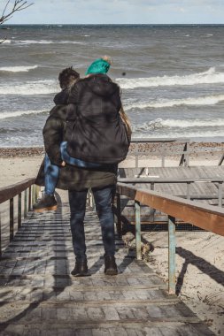 genç bir çift hafta sonları deniz kenarı soğuk Baltık Denizi, kumsalı, sıcak ceketler, Aile hafta sonu erkek ve kadın plajda çalışan harcama aşık.