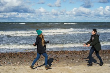 genç bir çift hafta sonları deniz kenarı soğuk Baltık Denizi, kumsalı, sıcak ceketler, Aile hafta sonu erkek ve kadın plajda çalışan harcama aşık.