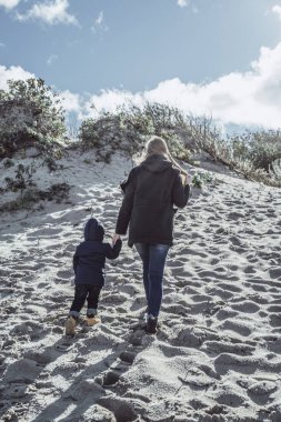 çocuklu genç bir aile hafta sonu soğuk Baltık Denizi, kumsalı, sıcak ceketler, Aile hafta sonu kıyısında küçük bir çocukla harcıyor