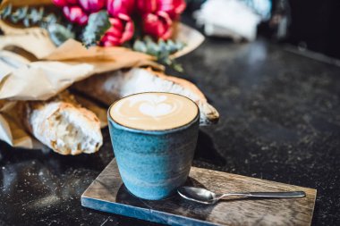 Bir kupa kahve cappuccino bir kafede masada ile. Smartphone, buket çiçek ve kapuçino. Tablo alanı organizasyonu