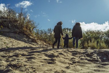 çocuklu genç bir aile hafta sonu soğuk Baltık Denizi, kumsalı, sıcak ceketler, Aile hafta sonu kıyısında küçük bir çocukla harcıyor