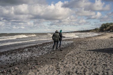 genç bir çift hafta sonları deniz kenarı soğuk Baltık Denizi, kumsalı, sıcak ceketler, Aile hafta sonu erkek ve kadın plajda çalışan harcama aşık.