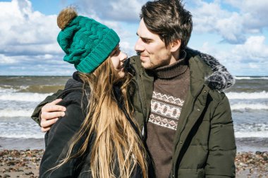 genç bir çift hafta sonları deniz kenarı soğuk Baltık Denizi, kumsalı, sıcak ceketler, Aile hafta sonu erkek ve kadın plajda çalışan harcama aşık.