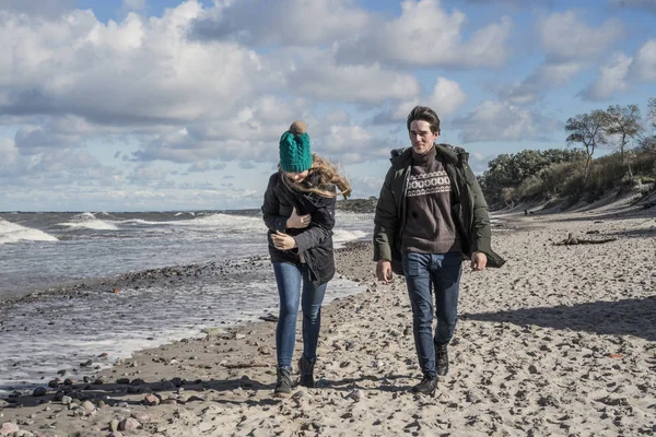 寒いバルト海 暖かいジャケット 家族週末男とビーチで走っている女性の海岸に週末を過ごす愛の若いカップル — ストック写真
