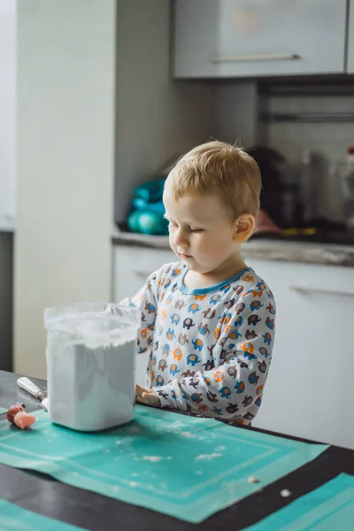 朝のパジャマの男の子と台所でアップルパイを調理しおもちゃで遊ぶ — ストック写真