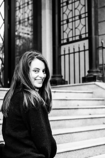 girl brunette runs down the stairs in the city and smiles