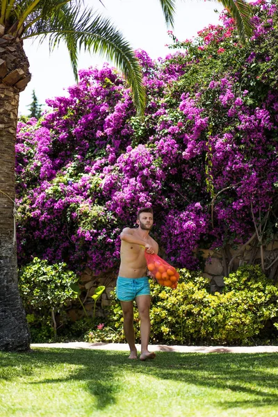 オレンジのバッグを裸の胸を持つ男に耐えます スペイン — ストック写真