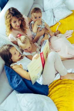 Üç çocuk kendinizi evinizde gibi hissedeceğiniz bir atmosferde bir kitap okuma ebeveynler ve çocuklar ile zaman paylaşımı anne. Anne, iki kızı ve küçük oğlu.