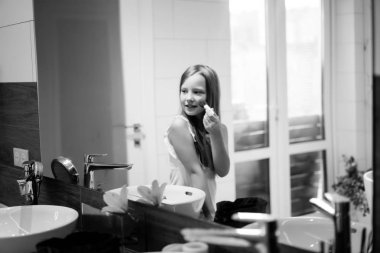 Anne ve kızı banyoda makyaj yapmak, aynanın önünde ruj uygulayın. Anne ve kızı birlikte vakit geçirmek iyi eğlenceler.