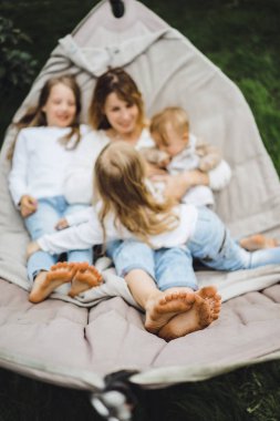 bir hamakta eğleniyor çocuk anne. Anne ve çocuklar bir hamak. Aile ile çocuk bahçesinde vakit geçiriyor.