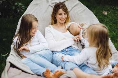 bir hamakta eğleniyor çocuk anne. Anne ve çocuklar bir hamak. Aile ile çocuk bahçesinde vakit geçiriyor.