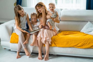 Üç çocuk kendinizi evinizde gibi hissedeceğiniz bir atmosferde bir kitap okuma ebeveynler ve çocuklar ile zaman paylaşımı anne. Anne, iki kızı ve küçük oğlu.