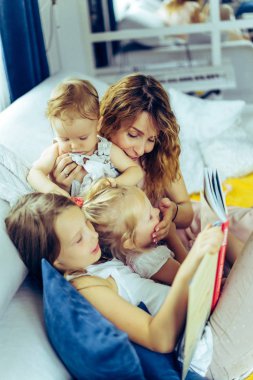 Üç çocuk kendinizi evinizde gibi hissedeceğiniz bir atmosferde bir kitap okuma ebeveynler ve çocuklar ile zaman paylaşımı anne. Anne, iki kızı ve küçük oğlu.