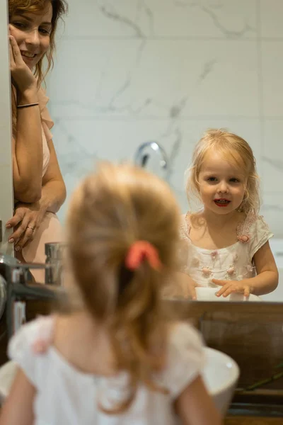 妈妈和女儿在浴室化妆 在镜子前涂口红 妈妈和女儿们玩得开心 花时间在一起 — 图库照片