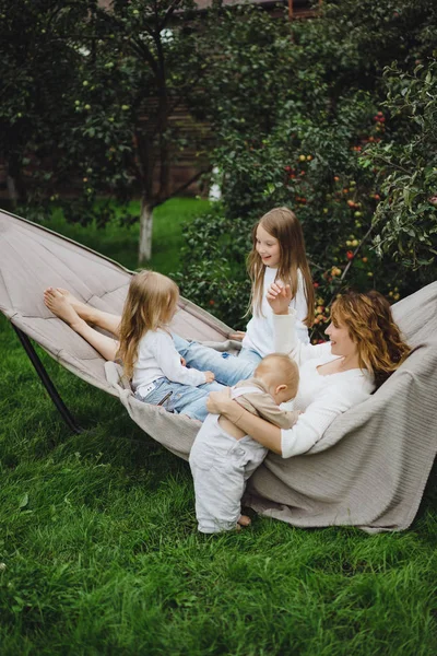 ハンモックで楽しく子供と母親 ママと子供たちはハンモックで 家族が 庭で子供との時間を費やしてください — ストック写真