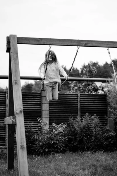 ブランコに乗っている子 お庭のブランコの揺れの女の子 夏のお楽しみ — ストック写真
