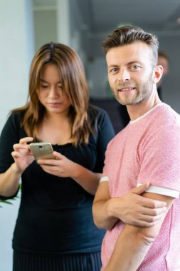 close up.boss iş arkadaşlarına akıllı telefon ekranında bilgi gösterir. gençler haberleri paylaşır, akıllı telefonda video gösterir,