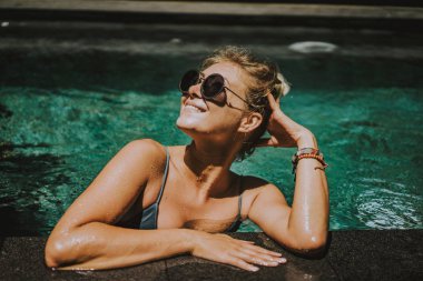 erkek tatilde. Güzel genç kadın havuzda yüzüyor.