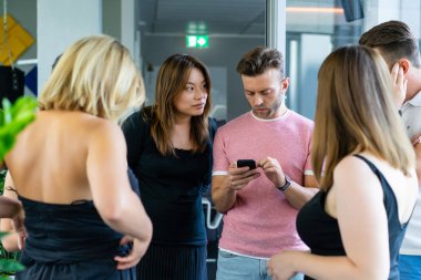 close up.boss iş arkadaşlarına akıllı telefon ekranında bilgi gösterir. gençler haberleri paylaşır, akıllı telefonda video gösterir,
