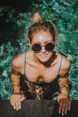 erkek tatilde. Güzel genç kadın havuzda yüzüyor.