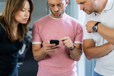 close up.boss iş arkadaşlarına akıllı telefon ekranında bilgi gösterir. gençler haberleri paylaşır, akıllı telefonda video gösterir,