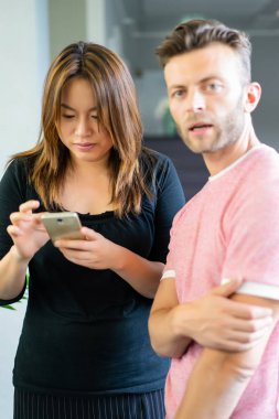 close up.boss iş arkadaşlarına akıllı telefon ekranında bilgi gösterir. gençler haberleri paylaşır, akıllı telefonda video gösterir,