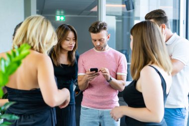 close up.boss iş arkadaşlarına akıllı telefon ekranında bilgi gösterir. gençler haberleri paylaşır, akıllı telefonda video gösterir,