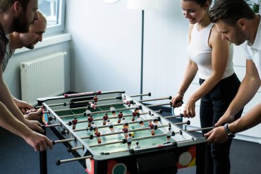 ofiste masa futbolu oynayan ve birlikte eğlenmek mutlu yöneticileri