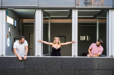 Geniş pencereli bir ofiste duran bir grup genç.