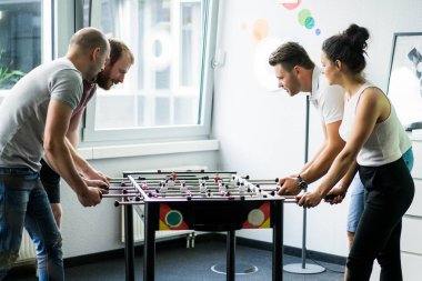 ofiste masa futbolu oynayan ve birlikte eğlenmek mutlu yöneticileri