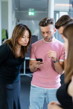 close up.boss iş arkadaşlarına akıllı telefon ekranında bilgi gösterir. gençler haberleri paylaşır, akıllı telefonda video gösterir,