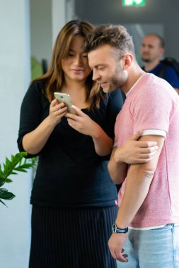 close up.boss iş arkadaşlarına akıllı telefon ekranında bilgi gösterir. gençler haberleri paylaşır, akıllı telefonda video gösterir,