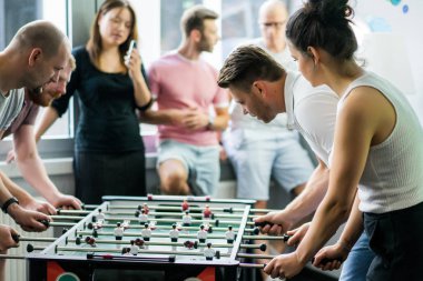 ofiste masa futbolu oynayan ve birlikte eğlenmek mutlu yöneticileri