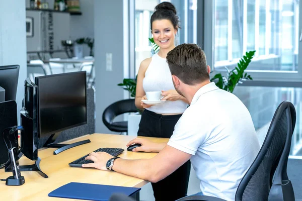 Full concentration at work. Group of young business people working and communicating while sitting at the office desk together with colleagues sitting in the background