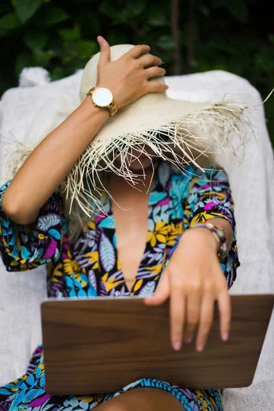 Woman freelancer, travel blogger works on a laptop. sitting on a — Stock Photo, Image