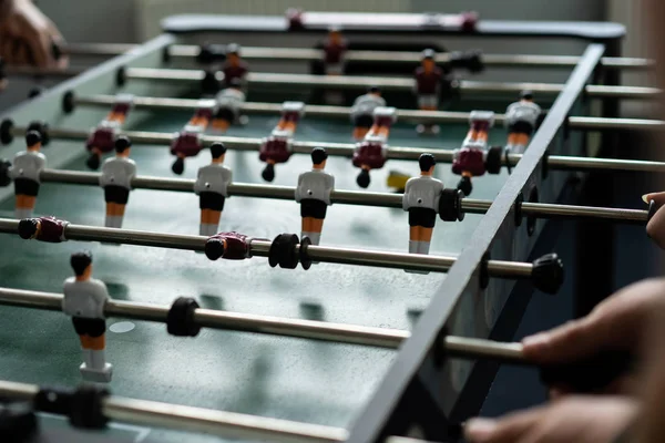 happy managers playing table football at office and having fun together