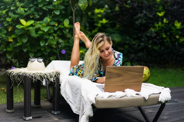 Freelancer mulher, blogueiro de viagens trabalha em um laptop. sentado em um — Fotografia de Stock