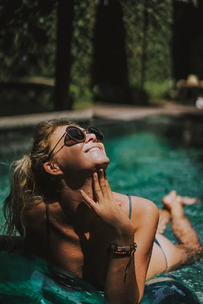 女性在度假 美丽的年轻女子在一个充气圈的池子里游泳 — 图库照片