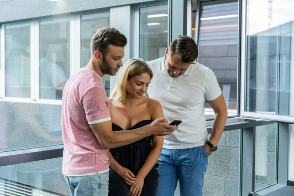 close up.boss shows colleagues information on the smartphone screen.  young people share news, show videos on a smartphone, discuss