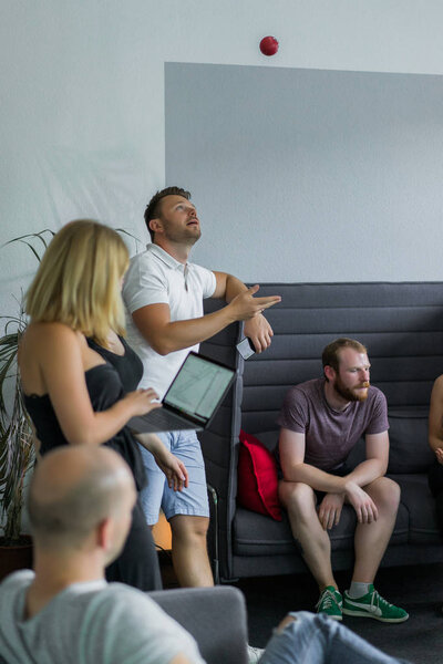 Красивые бизнесмены используют гаджеты, разговаривают и улыбаются во время конференции в офисе