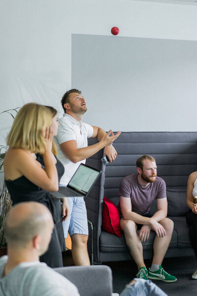 Красивые бизнесмены используют гаджеты, разговаривают и улыбаются во время конференции в офисе