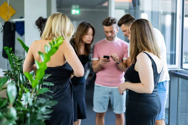 close up.boss shows colleagues information on the smartphone screen.  young people share news, show videos on a smartphone, discuss